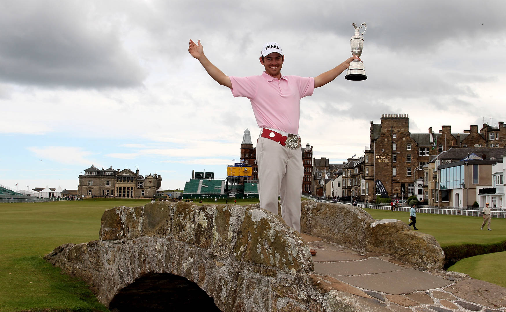 Louis Oosthuizen poses with the Claret Jug on the famous Swilcan Bridge.